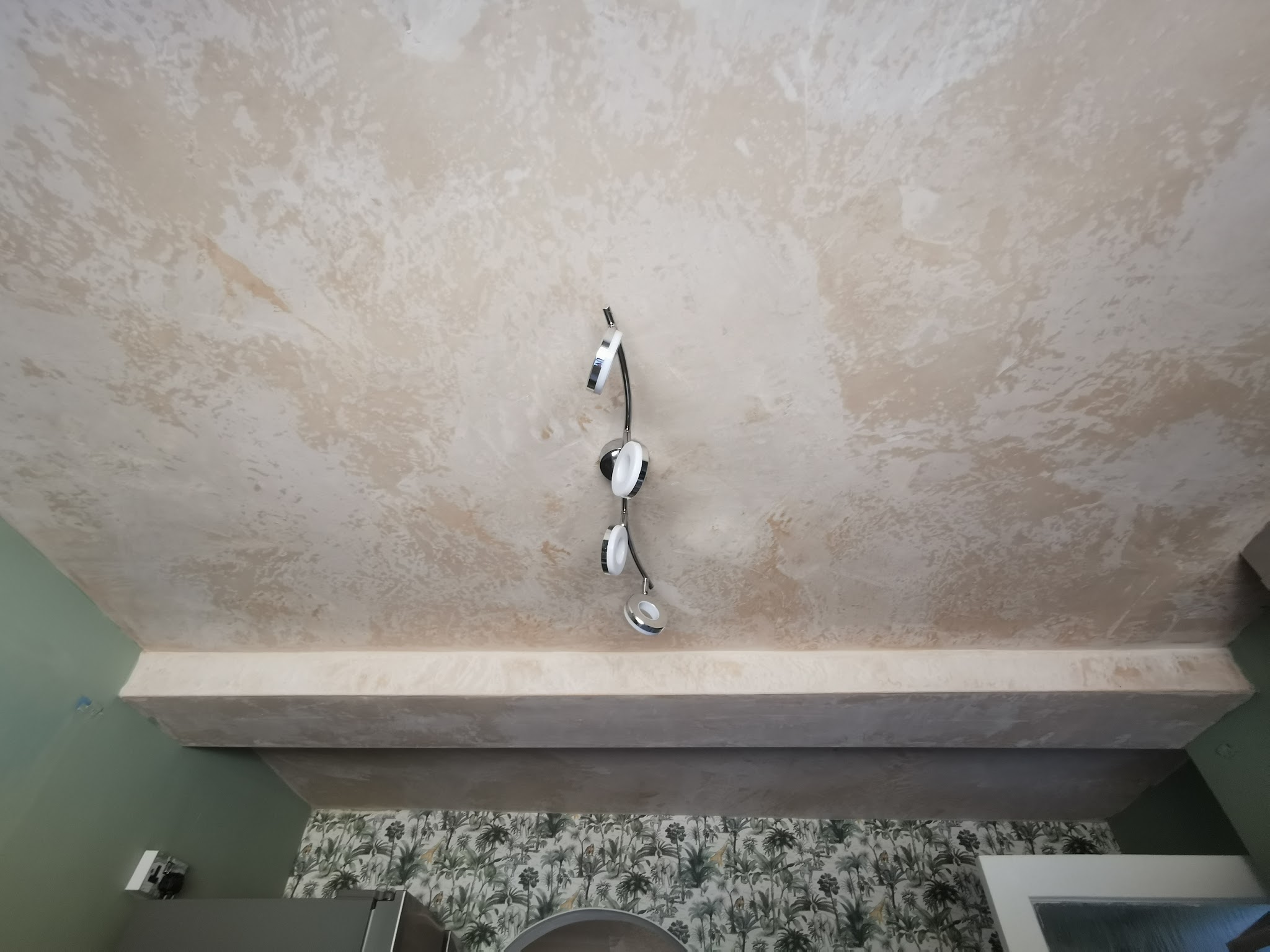 Freshly plastered bathroom wall above a boxed-in bath