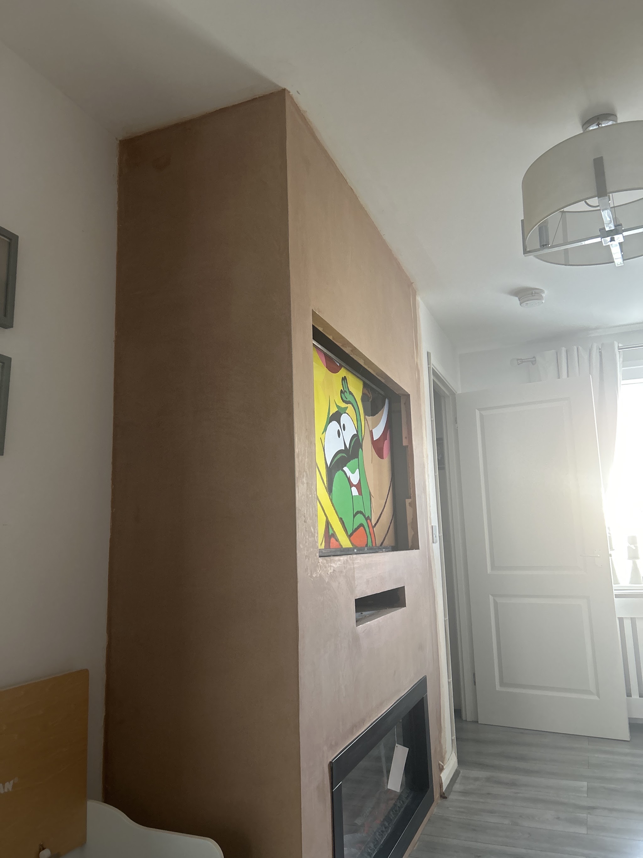 Freshly plastered media wall with an inset fire